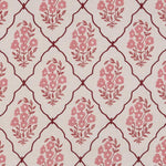 A close-up of a fabric or wallpaper pattern featuring a repeating trellis design in dark red on a warm cream background, with pink floral motifs inside each diamond.