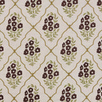 A close-up of a fabric pattern featuring dark brown floral clusters and olive green leaves, framed by a gold trellis design on a warm beige background.