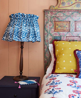 Image of Molly Mahon's new ikat flirty skirt lampshade in blue standing on a beside table.