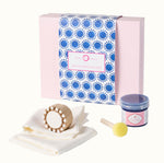 Block printing kit with packaging, wooden block, ink pad, and cloths on a white background