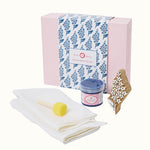 Block printing kit with a pink box, white cloth, printing block, and container on a white background