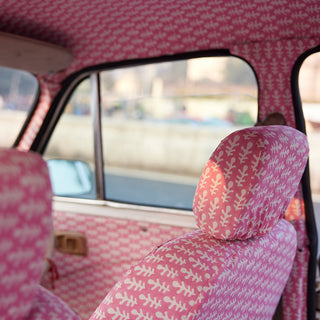Ambassador Indian taxi upholstered in Molly Mahon hand block printed Bagru pink design finished off with Molly Mahon hand block printed Mughal design window curtains tied back giving an injection of colour and joy for the passenger
